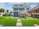 Luxury backyard featuring a pool with a swim-up bar, outdoor seating, and lush green lawn, perfect for outdoor entertainment at 244 Willow Ave, Anna Maria, FL 34216