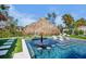 Luxurious pool featuring a swim-up bar under a charming tiki hut, perfect for relaxation and entertaining in style at 244 Willow Ave, Anna Maria, FL 34216