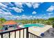 Aerial view of a community pool surrounded by lush landscaping, poolside furniture, and a tiki bar at 3009 Live Oak Ln # 33, Palmetto, FL 34221