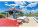 A vibrant poolside tiki bar featuring stools, a table with chairs, a grill, and scenic views at 3009 Live Oak Ln # 33, Palmetto, FL 34221