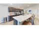 This kitchen features a large quartz breakfast bar, stainless steel appliances, and dark wood cabinets at 3126 58Th E Way, Palmetto, FL 34221