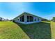 Spacious backyard featuring a screened lanai, lush green lawn, and exterior of home at 3126 58Th E Way, Palmetto, FL 34221