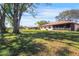 View of a spacious backyard with mature trees and a well-maintained lawn at 314 Signorelli Dr, Nokomis, FL 34275