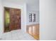 Bright foyer featuring tile flooring, a wooden front door with sidelight, and views into the living space at 314 Signorelli Dr, Nokomis, FL 34275
