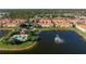 Aerial view of townhomes near a pool, scenic lake with fountain, and lush green landscaping in a vibrant community at 3456 Parkridge Cir # 33-105, Sarasota, FL 34243
