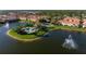 An aerial showing of the residences close to a tranquil lake with a fountain and a nearby swimming pool at 3456 Parkridge Cir # 33-105, Sarasota, FL 34243