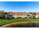 Townhomes with fenced patios overlooking a serene pond, complemented by lush green lawns and tranquil water views at 3456 Parkridge Cir # 33-105, Sarasota, FL 34243