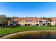 Townhomes with patios that overlook a serene pond, complemented by lush green lawns and tranquil water views at 3456 Parkridge Cir # 33-105, Sarasota, FL 34243
