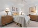 Bedroom with bedside lamps and decorative paintings on the wall at 3456 Parkridge Cir # 33-105, Sarasota, FL 34243