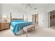 Nicely staged bedroom with ensuite bath access, bench, and ceiling fan at 3456 Parkridge Cir # 33-105, Sarasota, FL 34243
