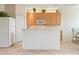 Eat in kitchen with white appliances, wooden cabinets, and a breakfast bar open to the living room at 3456 Parkridge Cir # 33-105, Sarasota, FL 34243