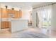 Bright kitchen and living room area with tile floors and door to lanai with a view to the lake at 3456 Parkridge Cir # 33-105, Sarasota, FL 34243