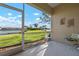 Screened patio overlooking a serene lake with lush green landscaping and clear blue skies at 3456 Parkridge Cir # 33-105, Sarasota, FL 34243