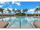 Beautiful community swimming pool, landscaped with palm trees, and nearby community buildings at 3456 Parkridge Cir # 33-105, Sarasota, FL 34243