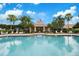Relaxing community swimming pool with shaded seating area, palm trees and easy access to community room at 3456 Parkridge Cir # 33-105, Sarasota, FL 34243