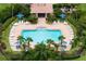 Upscale community swimming pool featuring sun loungers, shaded tables, and lush tropical landscaping at 3456 Parkridge Cir # 33-105, Sarasota, FL 34243