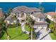 A luxurious two-story home featuring a three-car garage, mature palms, and elegant architectural details and waterfront at 348 W Royal Flamingo Dr, Sarasota, FL 34236