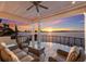 Relaxing waterfront balcony seating area with ceiling fan overlooking scenic sunset and water view at 348 W Royal Flamingo Dr, Sarasota, FL 34236