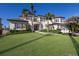 A luxurious two-story home featuring a well-manicured lawn, mature palms, and elegant architectural details at 348 W Royal Flamingo Dr, Sarasota, FL 34236