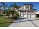 Spacious three-car garage with a stone paver driveway and mature landscaping at 348 W Royal Flamingo Dr, Sarasota, FL 34236