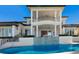 View of the pool and patio with covered balconies on multiple levels of the home at 348 W Royal Flamingo Dr, Sarasota, FL 34236