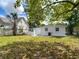 Picture of the backyard with grass and trees behind the house at 3512 N 10Th St, Tampa, FL 33605