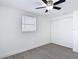 Well-lit bedroom featuring a ceiling fan, a window with blinds, and light grey flooring at 3512 N 10Th St, Tampa, FL 33605