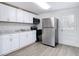 Well-lit kitchen featuring a stainless steel refrigerator and bright white cabinets at 3512 N 10Th St, Tampa, FL 33605