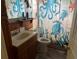 Functional bathroom featuring a vanity, toilet, and a shower with an ocean-themed curtain at 3525 Emory Dr, Holiday, FL 34691