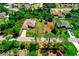 Aerial view of single-story home with long driveway, attached two-car garage, side lot, and screened pool in a green neighborhood at 3528 Monday Ter, North Port, FL 34286