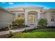 Charming home entrance with arched doorway, lush landscaping and inviting curb appeal at 3528 Monday Ter, North Port, FL 34286