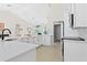 Bright kitchen with white cabinets, countertops, and a modern black faucet looking into the living area at 3528 Monday Ter, North Port, FL 34286