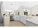 Modern kitchen with white cabinets, quartz countertops, stainless steel appliances, and an open floor plan at 3528 Monday Ter, North Port, FL 34286