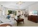 Bright living room features tile floors, tray ceiling, a ceiling fan, and a sliding glass door to the lanai at 3528 Monday Ter, North Port, FL 34286
