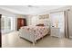 Bright main bedroom with a floral quilt, tile floors, and access to the outside through glass doors at 3528 Monday Ter, North Port, FL 34286