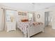 Bright main bedroom with a floral quilt, tile floors, and well-lit lamps on bedside tables at 3528 Monday Ter, North Port, FL 34286