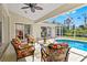 Relaxing screened-in pool patio area featuring comfortable seating and views of the pool and the lush backyard beyond at 3528 Monday Ter, North Port, FL 34286