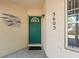 Charming front entrance featuring a teal door, stylish address numbers, and decorative fish art at 3605 60Th W St, Bradenton, FL 34209