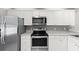 Modern kitchen with stainless steel appliances, white cabinets, and plenty of counter space at 3605 60Th W St, Bradenton, FL 34209