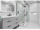 Modern bathroom with glass enclosed shower, gray vanity, and tiled walls at 3875 Catalina Dr, Bradenton, FL 34210