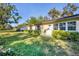 View of the building from the back yard featuring lush green grass and surrounding green foliage at 4058 Oakhurst Dr # 3174, Sarasota, FL 34233