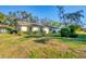 Exterior shot of building featuring green grass and surrounding trees and foliage at 4058 Oakhurst Dr # 3174, Sarasota, FL 34233