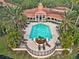 The community pool with lounge seating, and a clubhouse surrounded by palm trees at 4110 Central Sarasota Pkwy # 135, Sarasota, FL 34238