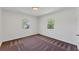 Bright bedroom with two windows, neutral walls, and patterned carpeting offers comfortable living space at 436 Parkview Dr, Sarasota, FL 34243