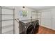 Functional laundry area features modern washer and dryer, shelving units, and tiled floor at 436 Parkview Dr, Sarasota, FL 34243