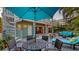 Inviting patio with dining and seating areas, adjacent to a spiral staircase and featuring lush tropical foliage at 4941 Commonwealth Dr, Sarasota, FL 34242