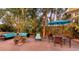 Secluded backyard with outdoor furniture, a large patio umbrella, and mature tropical landscaping with string lights at 4941 Commonwealth Dr, Sarasota, FL 34242