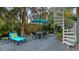 Outdoor living space with patio furniture, dining set, and spiral staircase, surrounded by lush tropical plants at 4941 Commonwealth Dr, Sarasota, FL 34242