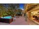 Serene backyard with a cozy seating area, lush tropical landscaping, string lights, and a spiral staircase at 4941 Commonwealth Dr, Sarasota, FL 34242