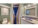 Neat bathroom showcasing tiled walls, a shower with a blue curtain, and a sink with a vanity at 4941 Commonwealth Dr, Sarasota, FL 34242